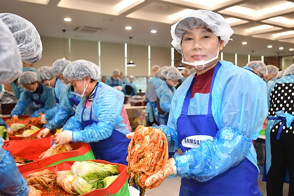 절인배추에 김장재료를 넣어 김장김치를 만들고 있는 봉사자들 사진