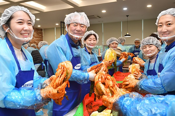 절인배추에 김장재료를 넣어 김장김치를 만들고 있는 봉사자들 사진